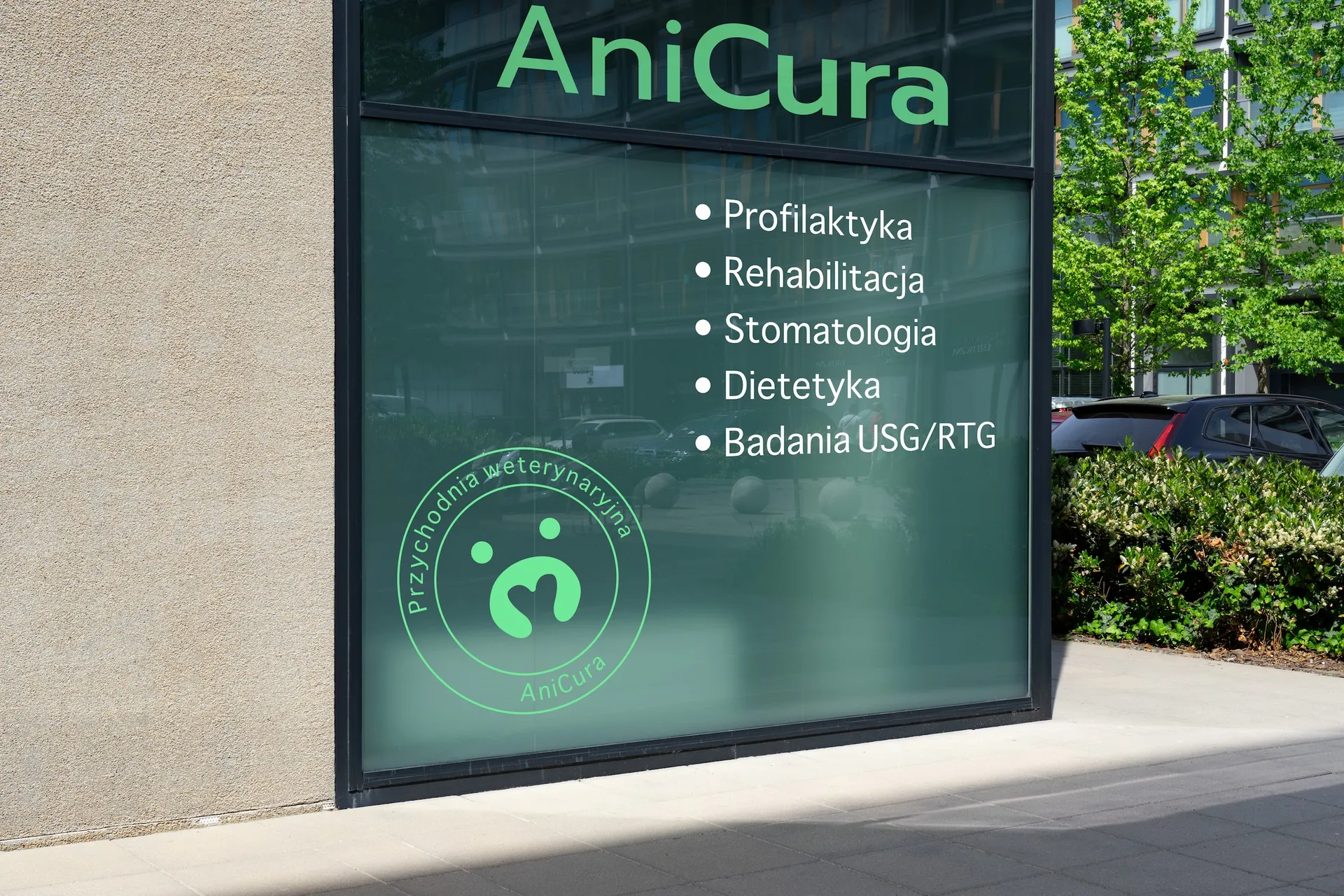 Witryna przychodni weterynaryjnej AniCura z logo i listą usług – profilaktyka, rehabilitacja, stomatologia, dietetyka, badania USG/RTG – na zielonym szkle